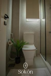 a bathroom with a toilet and a plant in it at Luxury 2BR City View Sokón R in Madinaty +13 photos