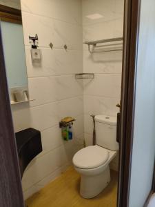 a bathroom with a white toilet and a sink at Apartemen Sky House BSD in Cilenggang +2 photos