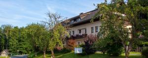 a white house with trees in front of it at Gästehaus Seewinkel in Presseggersee