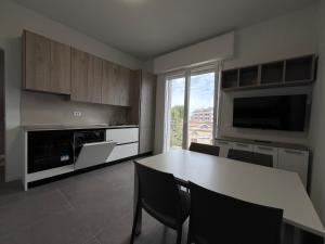 a kitchen with a table with chairs and a large window at Dealuna Motel in Fidenza