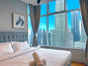 a bedroom with a bed with a large window at Sky Suites KLCC BY Arman in Kuala Lumpur