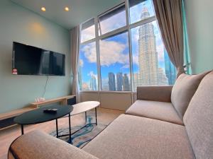 a living room with a couch and a large window at Sky Suites KLCC BY Arman in Kuala Lumpur