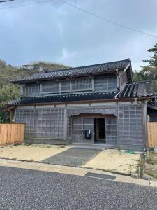 a gray house with a garage with a fence at Hanakaijichi, Explore the crustal movement every thousand years in Kuroshima