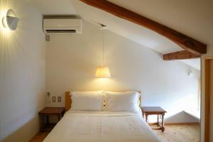 a bedroom with a large white bed with a lamp at Hanakaijichi, Explore the crustal movement every thousand years in Kuroshima