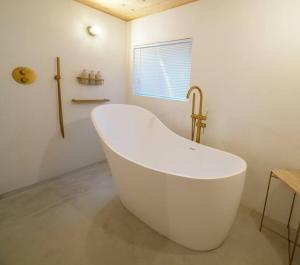 a white bath tub in a bathroom with a window at Hanakaijichi, Explore the crustal movement every thousand years in Kuroshima +80 photos
