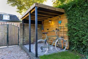 ein Fahrrad ist unter einem Holzschuppen geparkt in der Unterkunft De oude walnoot in Sint Pancras