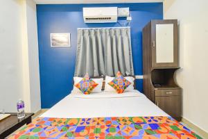 a bedroom with a bed and a blue wall at FabHotel Broholic Prime Suites - Kukatpally - Nr Nexus Mall in Hyderabad +23 photos