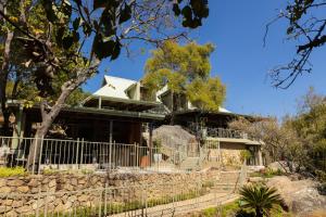 a house with a stone fence in front of it at Rupurara Valley Lodge in Juliasdale