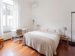 una camera da letto bianca con un letto e una scrivania di I Host Apartment - Orti 16 Scala D a Milano