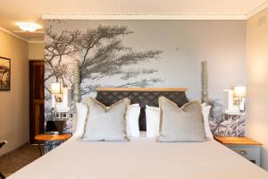 a bedroom with a large bed with white pillows at Rupurara Valley Lodge in Juliasdale +65 photos
