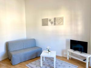 un salon avec un canapé bleu et une télévision dans l'établissement Sabine´s Ferienwohnung mit Bergblick am Chiemsee, à Prien am Chiemsee