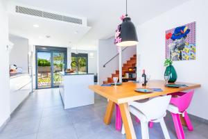 a kitchen and dining room with a wooden table and pink chairs at Villa Puerto Blanco in Vinaròs