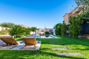 a backyard with two chairs and a swimming pool at Villa Puerto Blanco in Vinaròs
