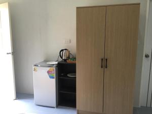 a kitchen with a cupboard next to a refrigerator at Sunshine guesthouse in Ban Saiyuan (1) +10 photos