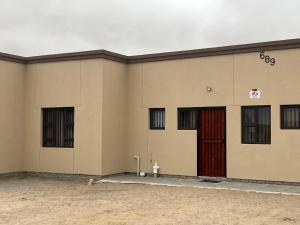 a building with a red door and a fire hydrant at Kiki's Inn Self-Catering & accommodation in Swakopmund