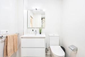 ein weißes Badezimmer mit Toilette und Waschbecken in der Unterkunft Castle Bank By CanariasGetaway in Guanarteme + 24 Fotos