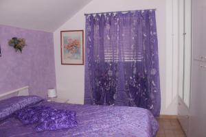 sypialnia z fioletowymi zasłonami i fioletowym łóżkiem w obiekcie B&B Angels w mieście Canosa Sannita