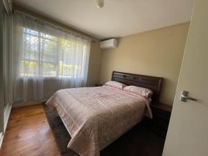ein Schlafzimmer mit einem Bett und einem großen Fenster in der Unterkunft Canberra Hospital Locum Welcome- 2BR Home in Harman
