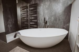 a white bath tub in a bathroom with gray walls at Panorama Lodge Edelweiss in Gosau