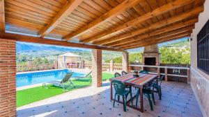 a patio with a table and chairs and a pool at Casa Rio Grande Tolox by Ruralidays in Tolox +16 photos