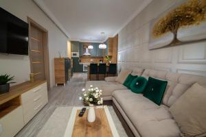 ein Wohnzimmer mit Sofa und Tisch in der Unterkunft Exclusive Cozy Apartment Adora Park Arad in Arad