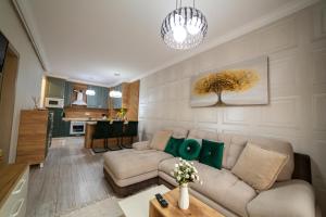 ein Wohnzimmer mit Sofa und Tisch in der Unterkunft Exclusive Cozy Apartment Adora Park Arad in Arad