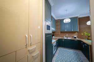 eine Küche mit grünen Schränken und einem Waschbecken in der Unterkunft Exclusive Cozy Apartment Adora Park Arad in Arad + 69 Fotos