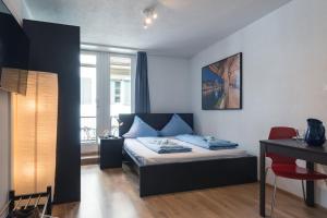 una camera da letto con un letto, un tavolo e una scrivania di HITrental Old Town Apartments a Lucerna Altre 87 foto