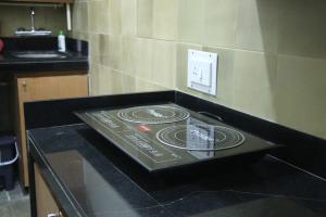 a black counter top with a stove in a kitchen at Fostel- The Fort Hostel in Mumbai
