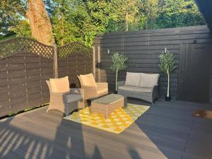 a patio with chairs and a couch and a table at Wood Lodge in Bungay