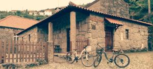 duas bicicletas estacionadas em frente a um edifício de pedra em Casa De Fora em Aboim