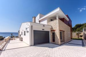 a white house with a garage at Seaview villa Marija in Duće