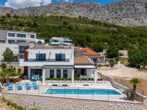 a house with a swimming pool and a mountain at Seaview villa Marija in Duće +42 photos
