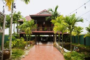 a house with palm trees in front of it at Homestay Pleiku Phố in Pleiku
