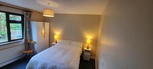 a bedroom with a white bed and two lamps at Hilltown House - Room Only in Wexford +8 photos