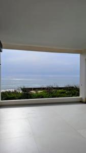 a large window with a view of the ocean at La Villa Relax - Maison neuve en bordure de mer à Guereo in Guéréo