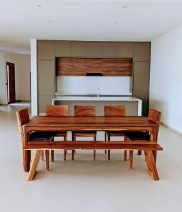 a wooden table and chairs in a room at La Villa Relax - Maison neuve en bordure de mer à Guereo in Guéréo