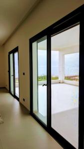 an empty room with a large sliding glass door at La Villa Relax - Maison neuve en bordure de mer à Guereo in Guéréo