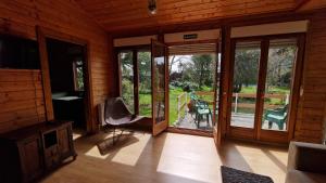 a room with sliding glass doors and a chair on a porch at A Leira - Chalet con Piscina en Becerril de la Sierra in Becerril de la Sierra