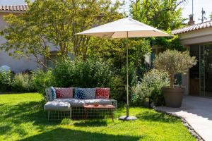 a garden with a couch and an umbrella at Hôtel 96 in Marseille
