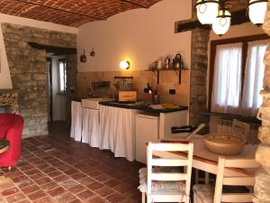 a kitchen with white counters and a table in a room at Casa Domenica - Home&more in Monastero Bormida