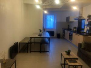a living room with a table and a kitchen at Maison de l'Abbaye des Prémontrés in Pont-à-Mousson +5 photos