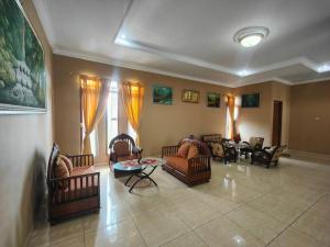 a living room with couches and chairs and a table at Padi Loka Villa Kuningan in Koreak
