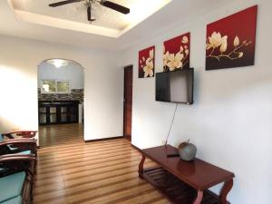 a living room with a table and a tv on a wall at Apong Martina's Guest House La Union in Lacong