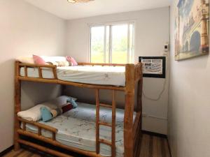 two bunk beds in a room with a window at Apong Martina's Guest House La Union in Lacong