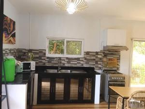 a kitchen with a sink and a stove at Apong Martina's Guest House La Union in Lacong +9 photos