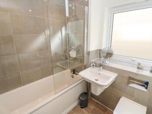 Un baño con ducha, lavabo y bañera. en 2 The Dunes, en Falmouth 20 fotos más