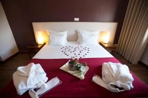 a hotel room with a bed with towels and a tray with hearts at Hotel Rali Viana in Viana do Castelo