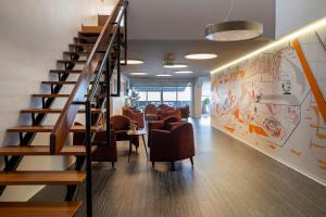 a lobby with chairs and stairs in a building at Hotel Rali Viana in Viana do Castelo