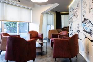a waiting room with chairs and a table at Hotel Rali Viana in Viana do Castelo